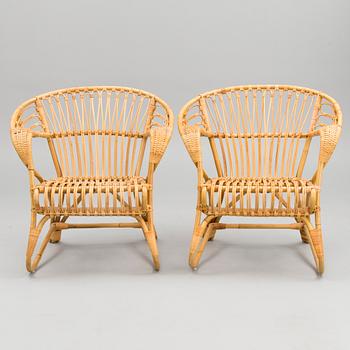 A pair of rattan arm chairs from the latter half of the 20th Century.