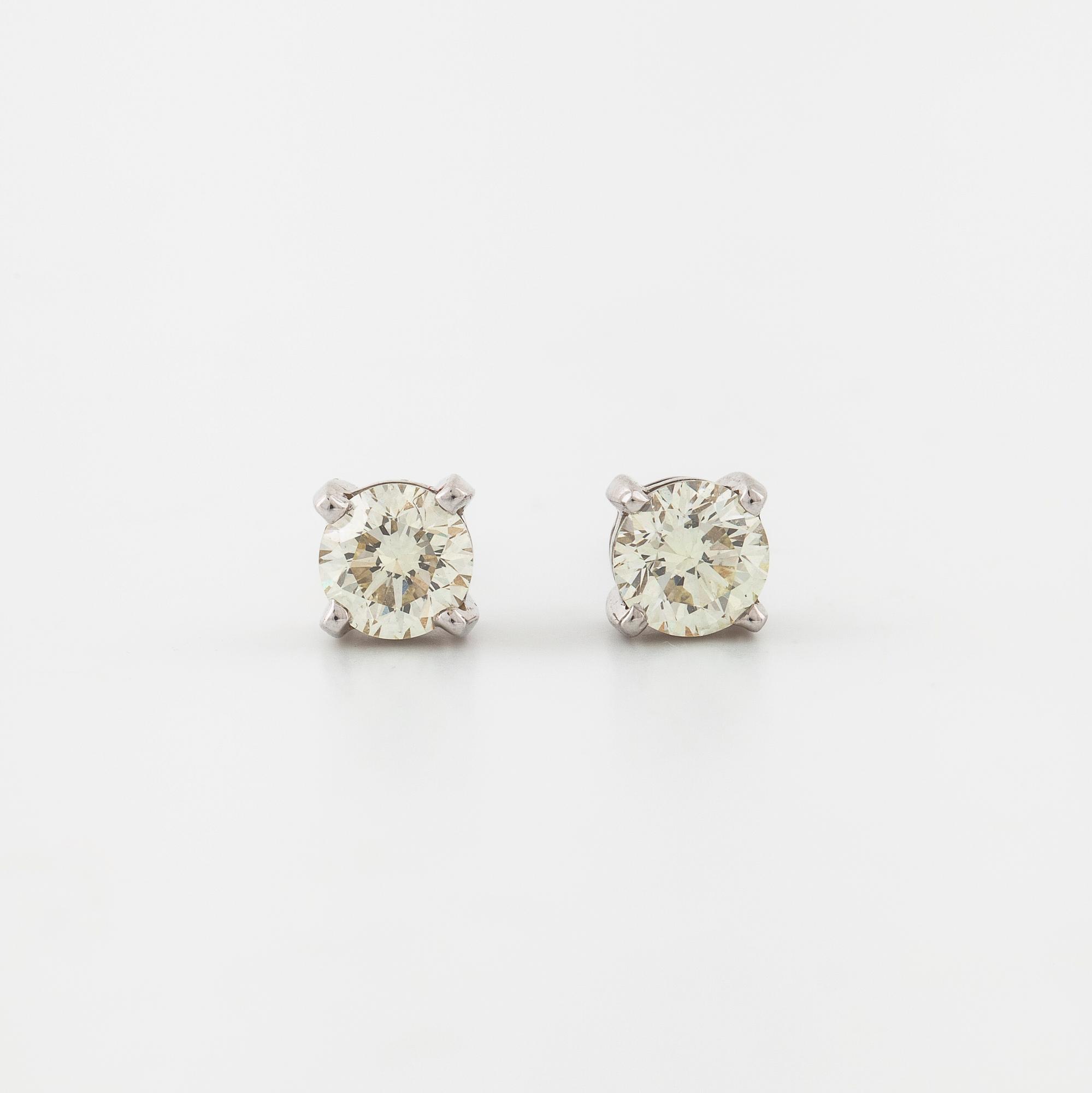A pair of brilliant cut diamond earrings.