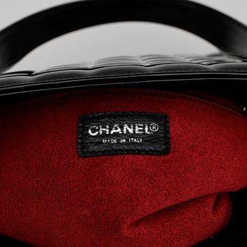 CHANEL, a quilted black patent leather top handle bag.