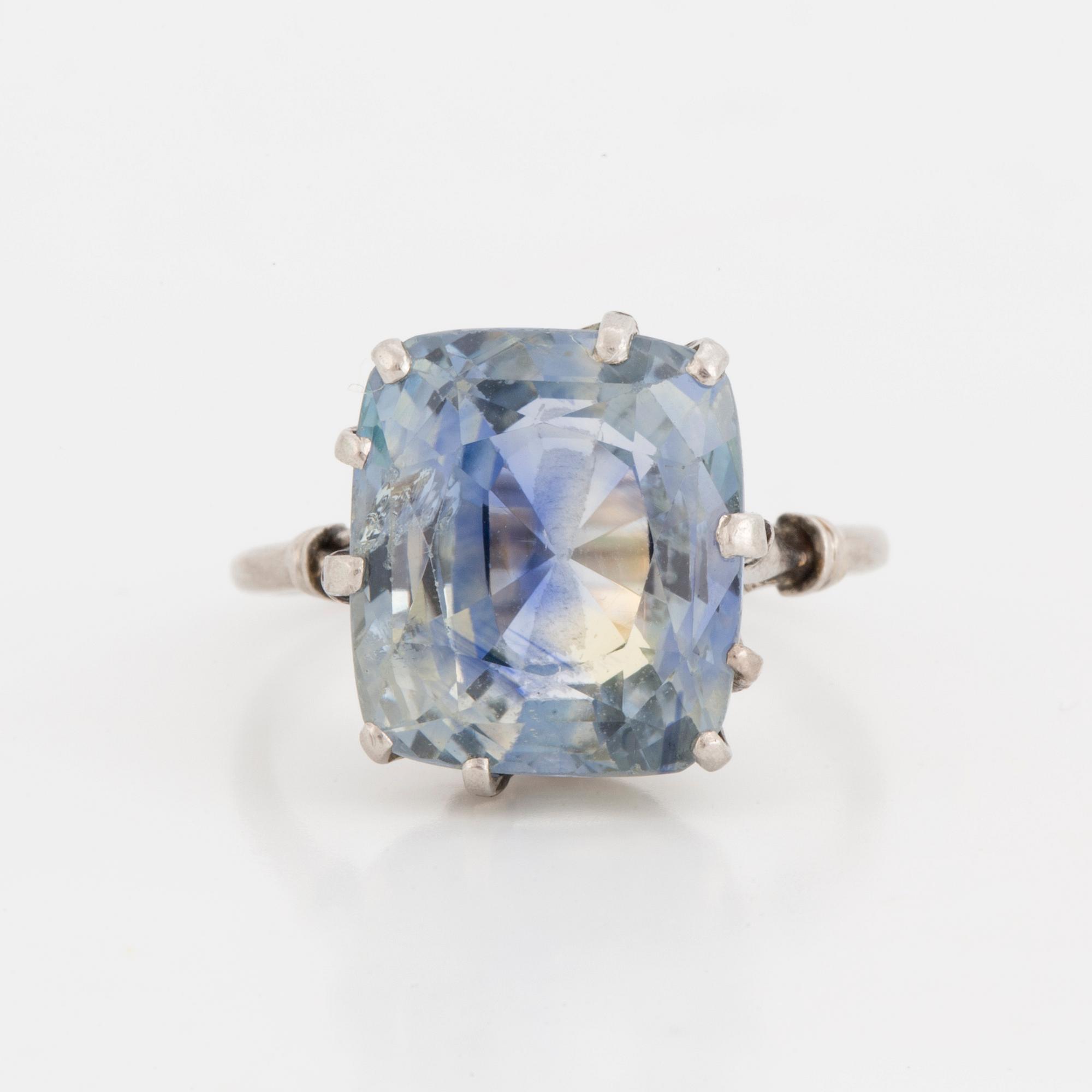 A ring set with a light blue, cushion-cut sapphire.
