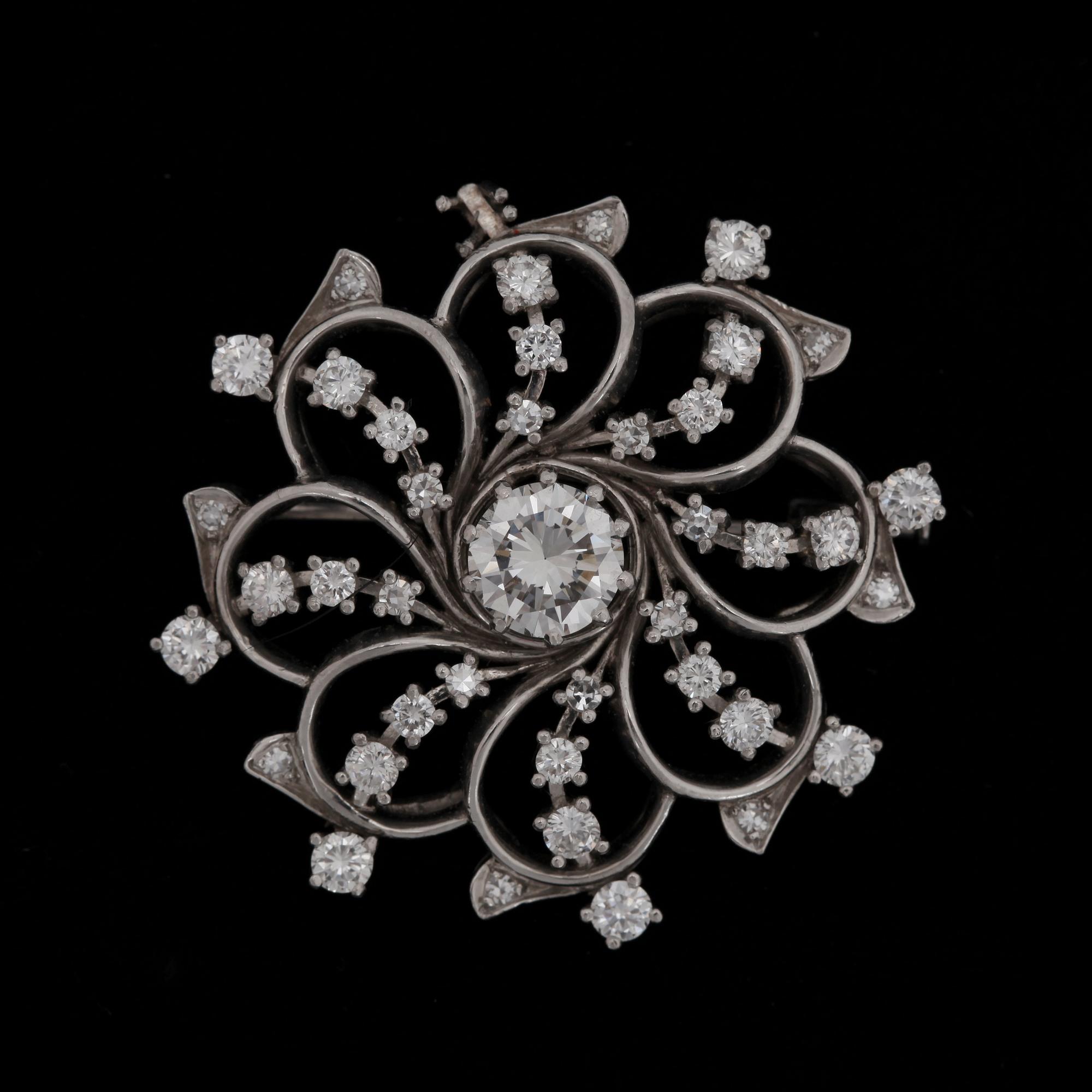 A brilliant cut diamond brooch, app. 1 ct, with brilliant cut diamonds tot. app. 0.90 ct.