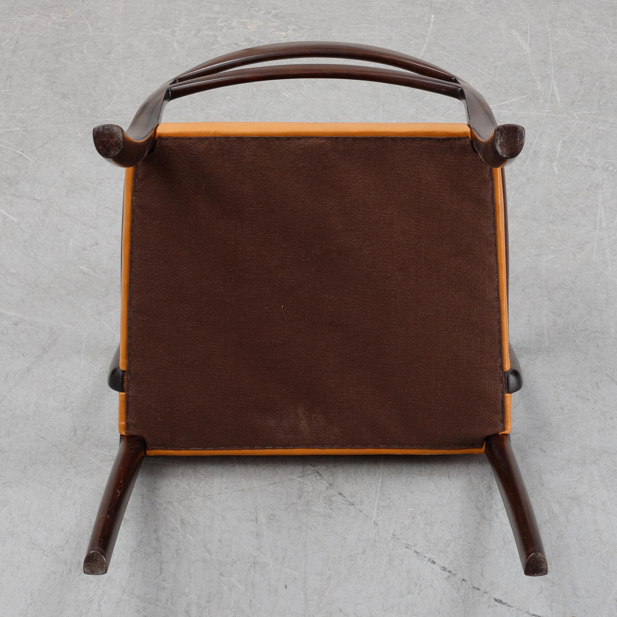 A set of four black stained beech tree arm chairs with leather upholstery, second half of the 20th century.