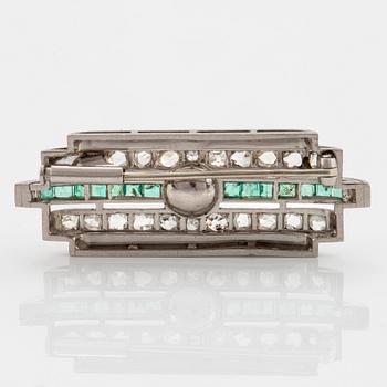 A platinum brooch set with old- and rose-cut diamonds, faceted emeralds and a pearl.