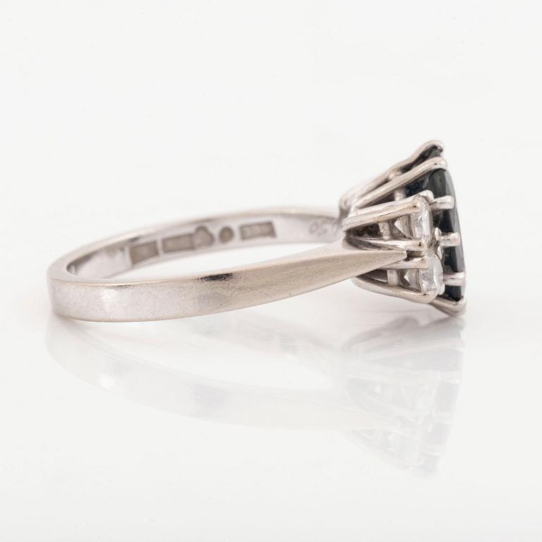 Ring med mökblå oval safir och briljantslipade diamanter.
