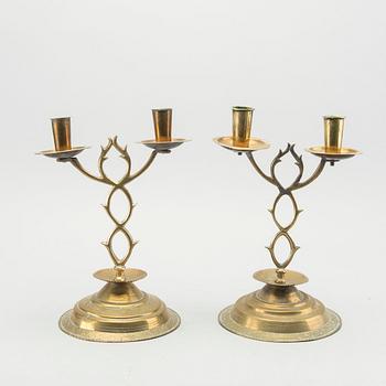 A pair of brass candelabras dated 1810 and 1812.