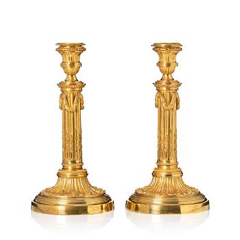 A pair of Louis XVI candlesticks in the manner of Jean Louis Prieurs.