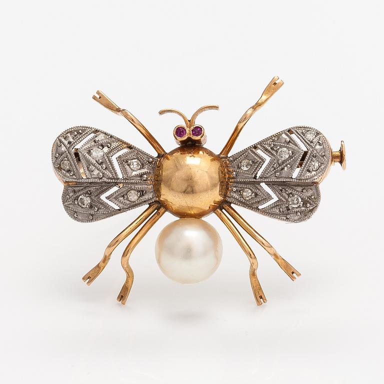 A 15-17K gold brooch with rubies, a cultured pearl and diamonds ca. 0.10 ct in total.