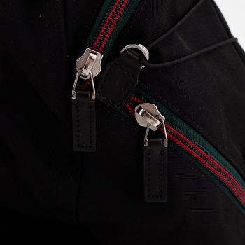Gucci, a black canvas backpack.