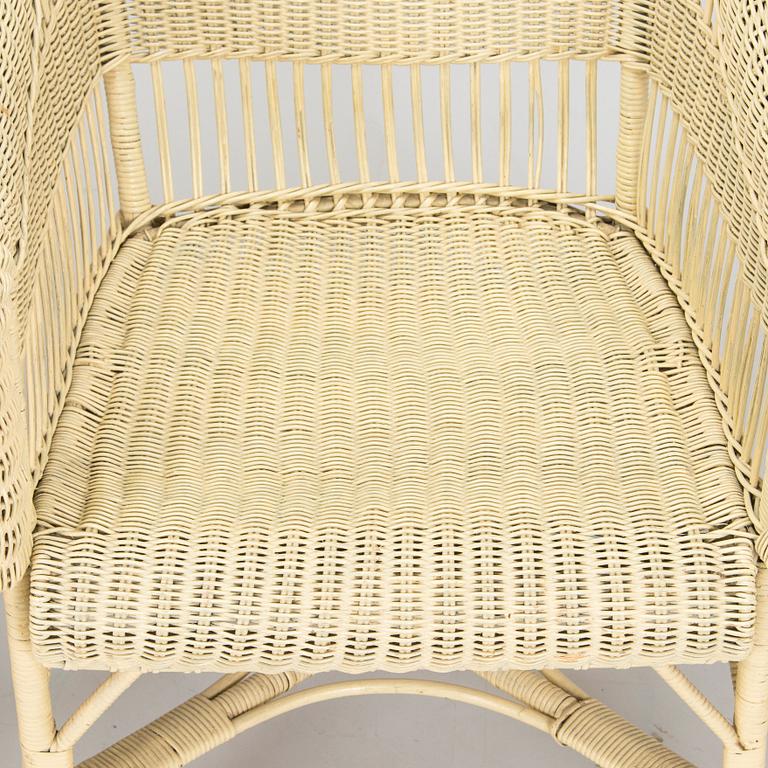 A mid-20th-century three-piece rattan furniture set including two armchairs, and a table.