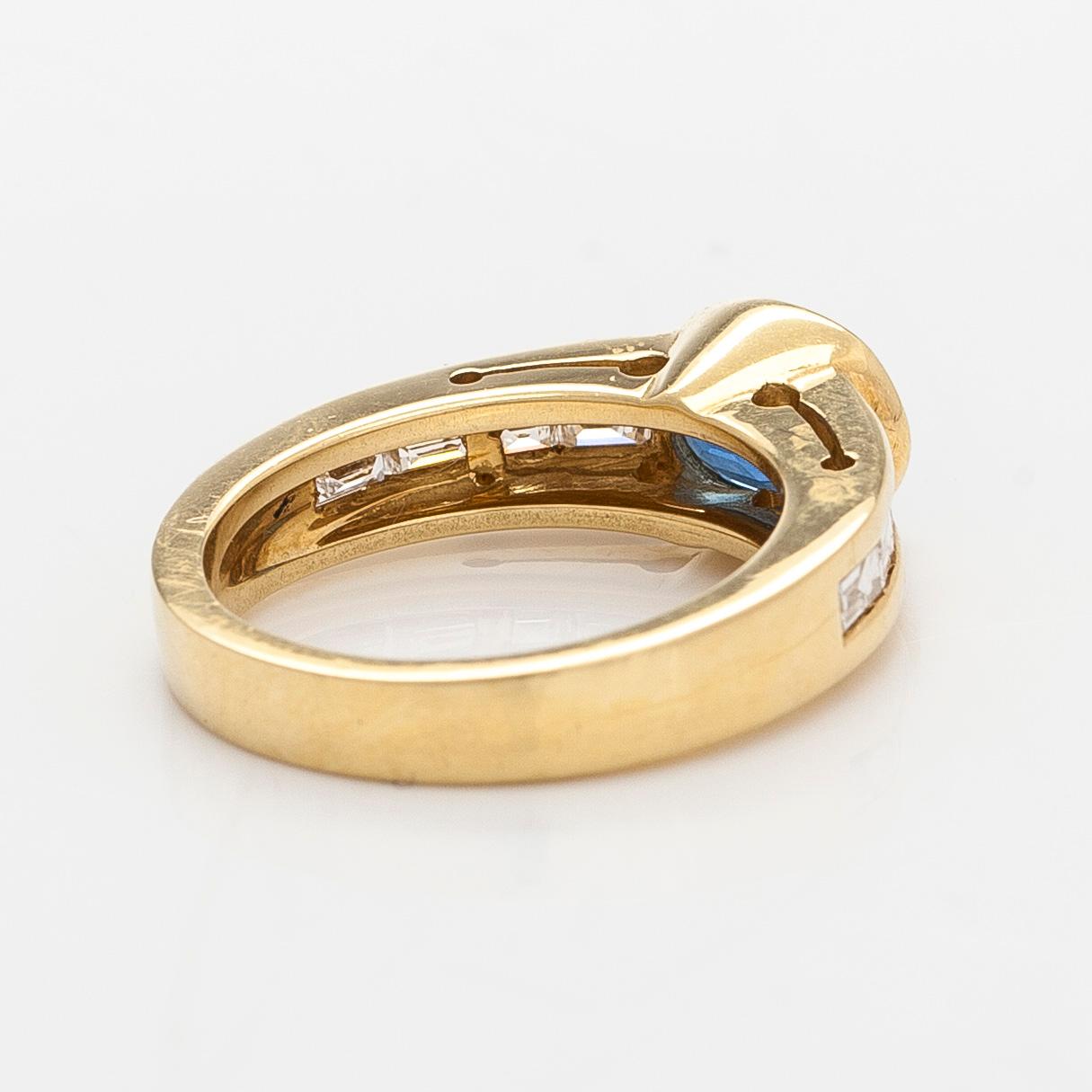 An 18K gold ring with an oval sapphire and baguette-cut diamonds. Finnish hallmarks, year 2000.