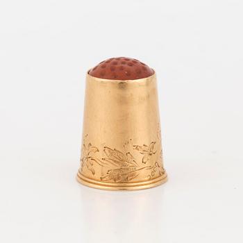 A thimble set with carnelian.