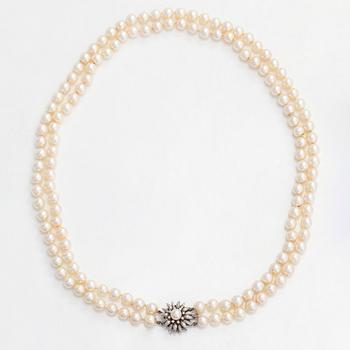 A double-stranded necklace, with cultured Akoya pearls, clasp in 14K white gold with brilliant-cut diamonds.