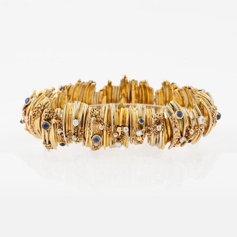 An 18K gold bracelet set with round brilliant-cut diamonds and cabochon-cut sapphires.