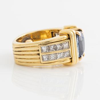 Ring in 18K gold set with an oval faceted sapphire and princess-cut diamonds.