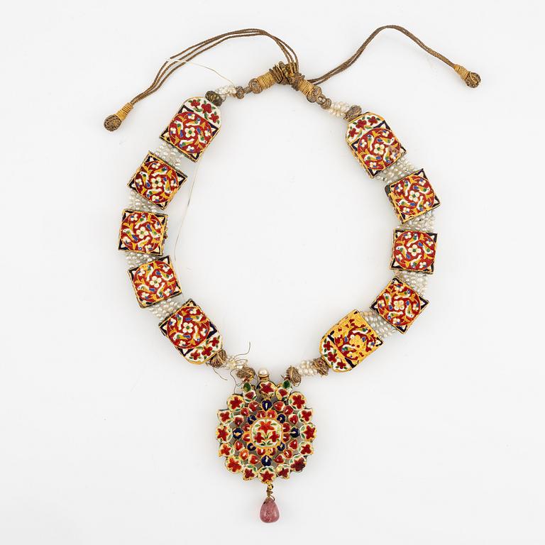 An antique gold and enamel Qajar necklace with pearls set with turquoises and with a garnet drop.