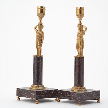 A pair of late gustavian early 19th century porphyry and ormolu candlesticks.