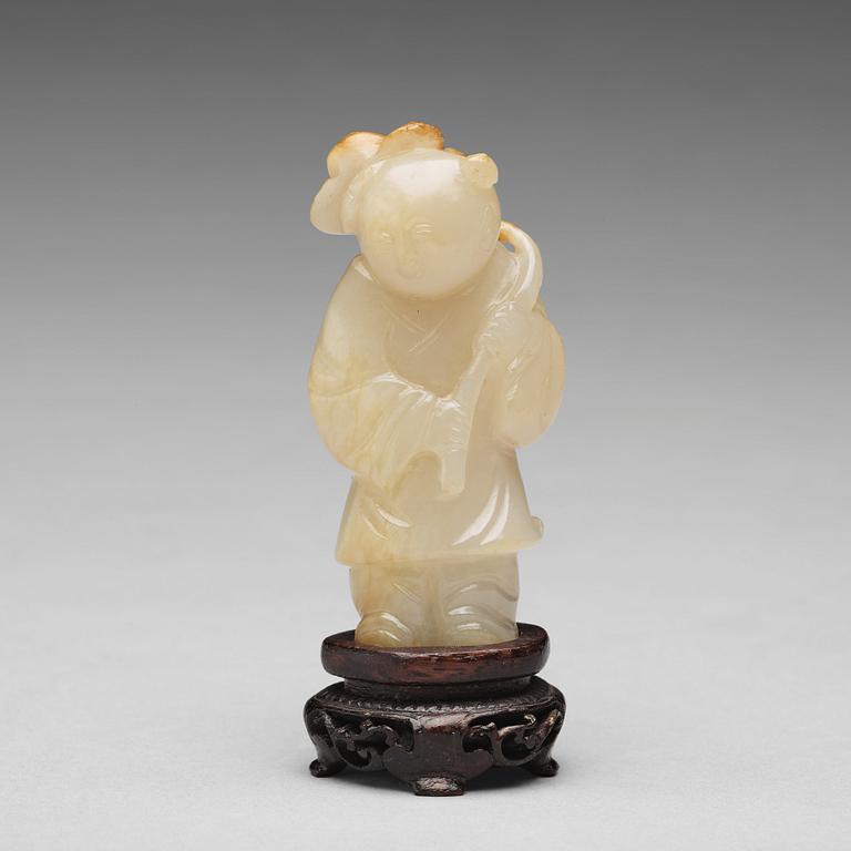 A carved nephrite figure of a boy with a lotus branch, Qing dynasty (1644-1912).