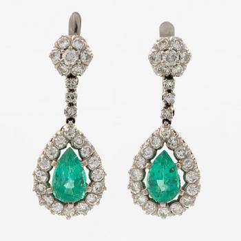 Earrings in platinum with drop-shaped emeralds and brilliant-cut and octagonal-cut diamonds.