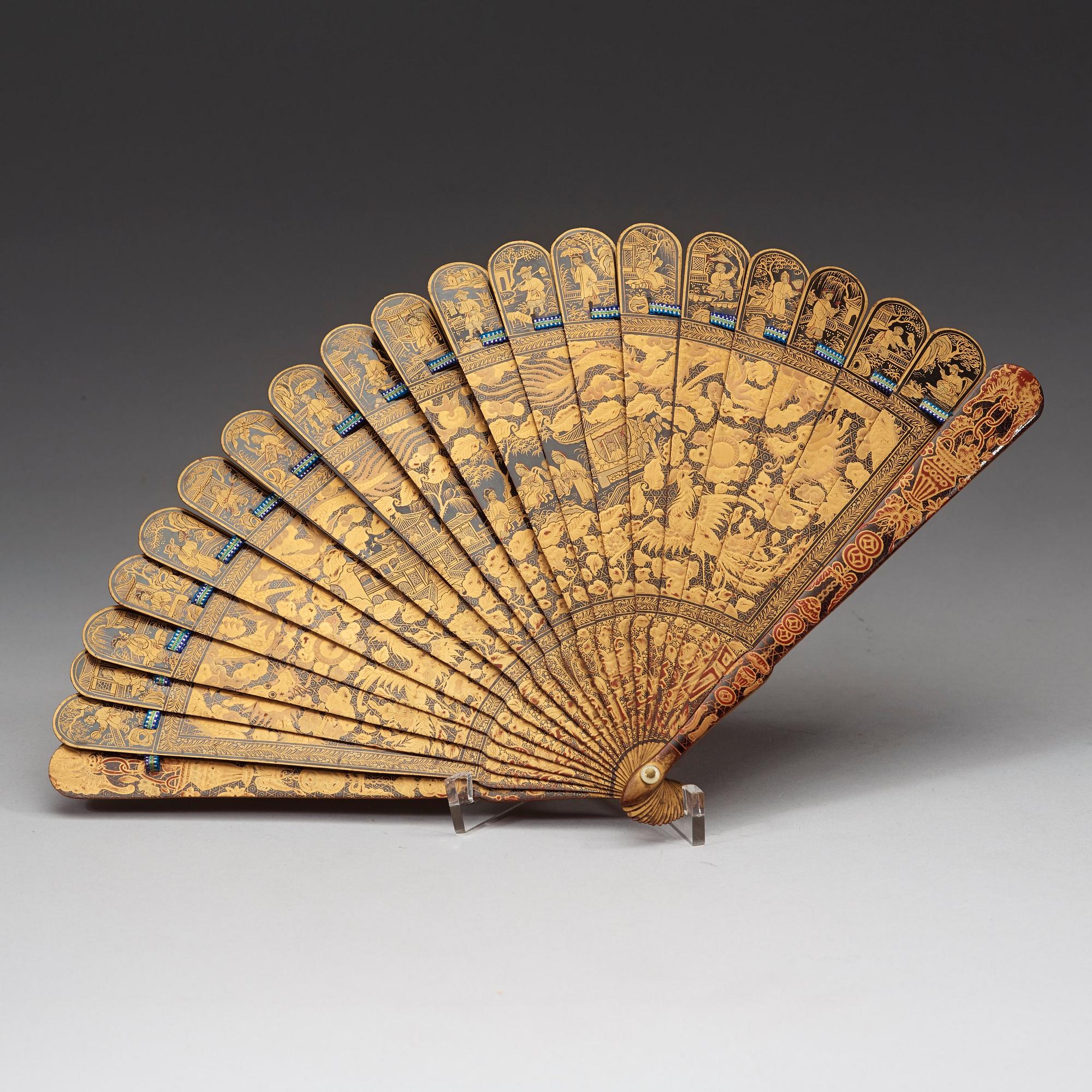 A black lacquer and gold fan in a silk clad box, Qing dynasty, 19th Century.