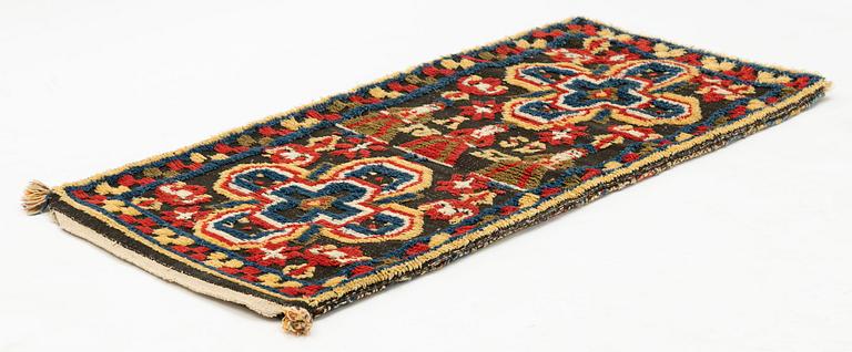 A carriage cushion, knotted pile in relief, c. 111 x 49, probably Ljunits district, signed ASD and dated 1852.