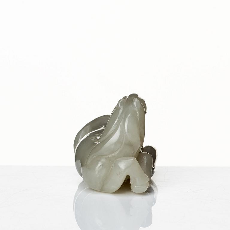 A carved nephrite figure of a reclining horse, Qing dynasty.