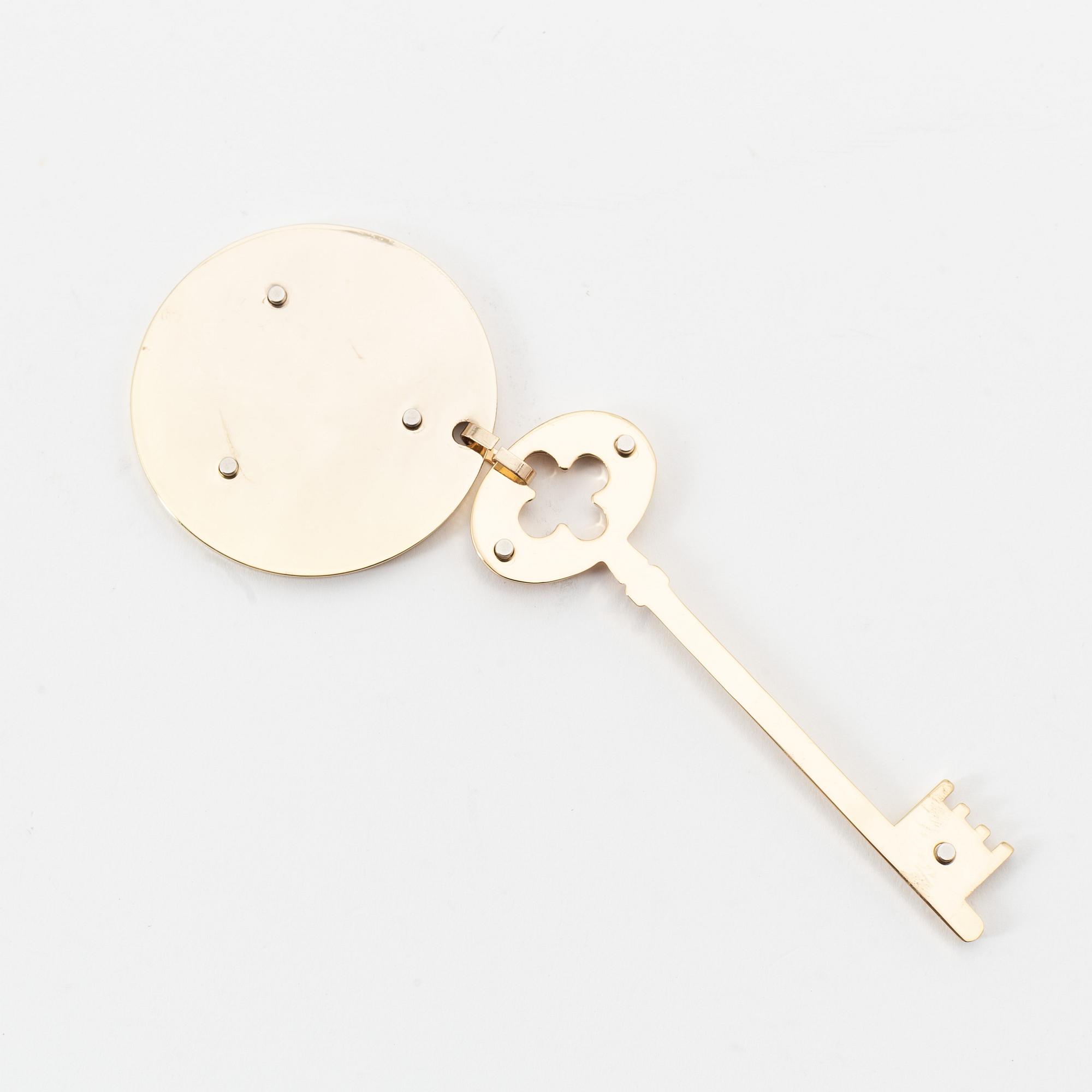 Louis Vuitton, a gold metal key magnet.