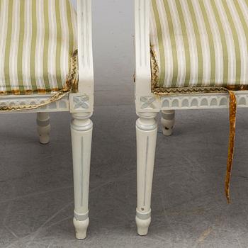 a mid 20th century dining table with four arm chairs.