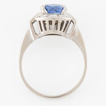 Ring 18K white gold set with a faceted sapphire and round brilliant-cut diamonds.