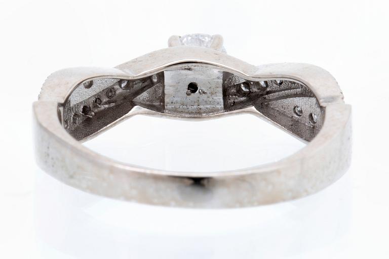 Ring 18K vitguld med 1 briljant ca 0,30 ct och briljanter ca 0,15 ct totalt.