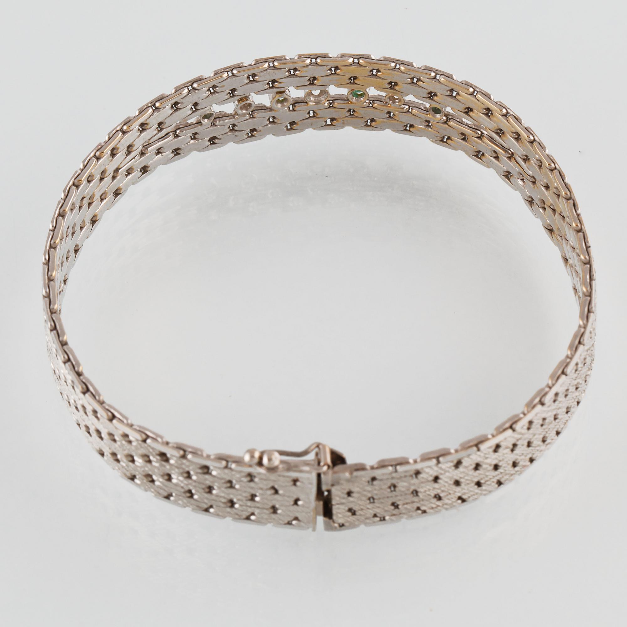 ARMBAND, 18K vitguld med en briljantslipad och 2 åttkantslipade diamanter samt 4 fasettslipade smaragder. Vikt 35,5 gram.