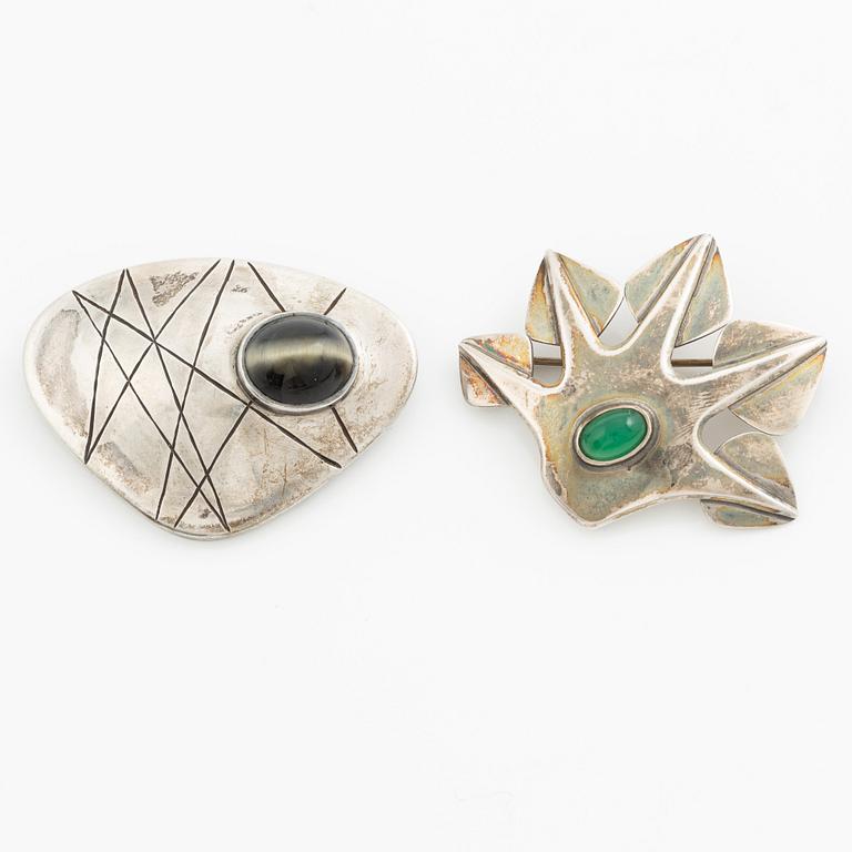 Två broscher, silver och stenar.