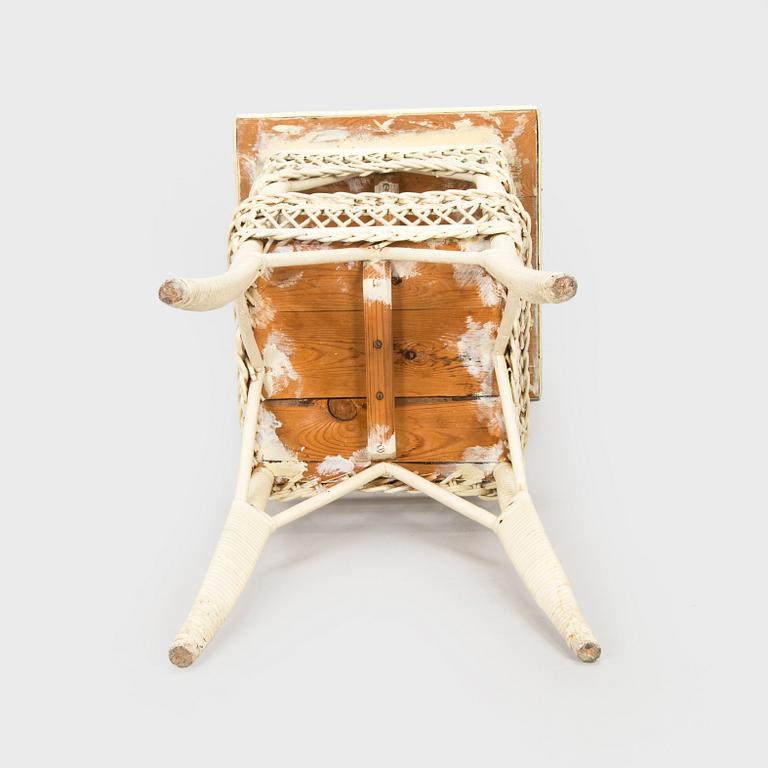 A mid-20th-century three-piece rattan furniture set including two armchairs, and a table.
