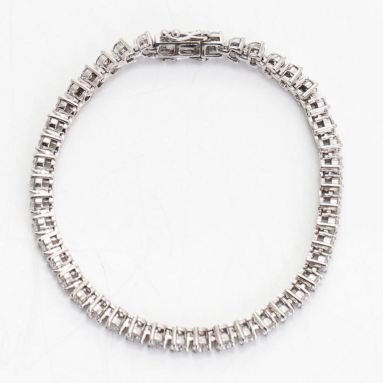 An 18K white gold tennis bracelet, with brilliant-cut diamonds.