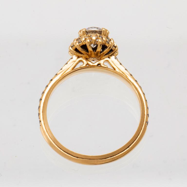 An 18K gold ring set with round brilliant-cut diamonds.