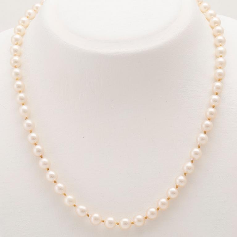 A necklace of cultured pearls with an 18K white gold lock set with single cut diamonds.