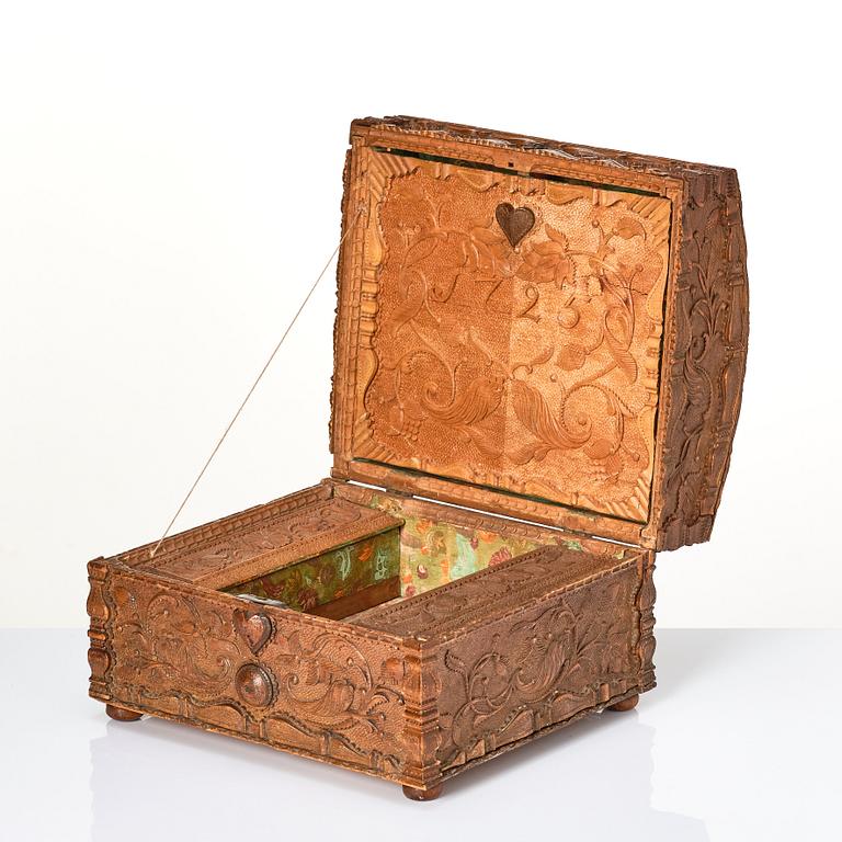 A baroque wedding casket, carved wood, dated 1725.