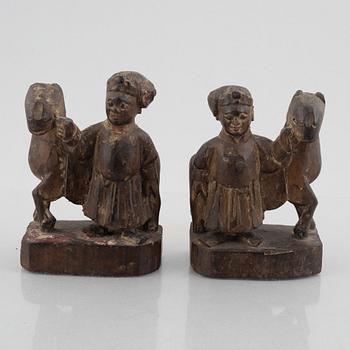A pair of wooden sculptures of men with horses, late Qing dynasty / around 1900.