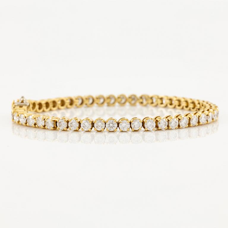 A tennis bracelet in 14K gold with round brilliant-cut diamonds.