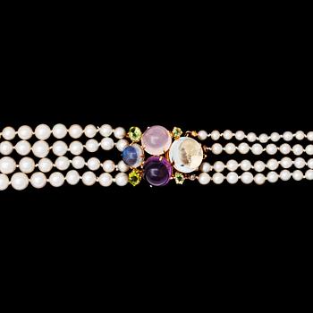 A four strand cultured pearl necklace with cabochon cut amethyst, rose quartz and aquamarine.