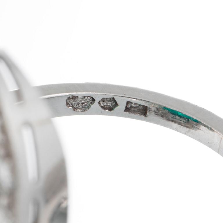 A platinum ring set with a cabochon-cut emerald ca 7 cts and brilliant and baguette-cut diamonds.