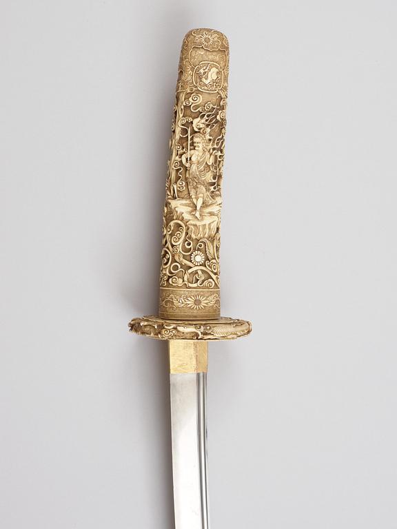 A elaborately sculptured Japanese ceremonial sword, Meiji (1868-1912), with an older blade originally from a long sword.