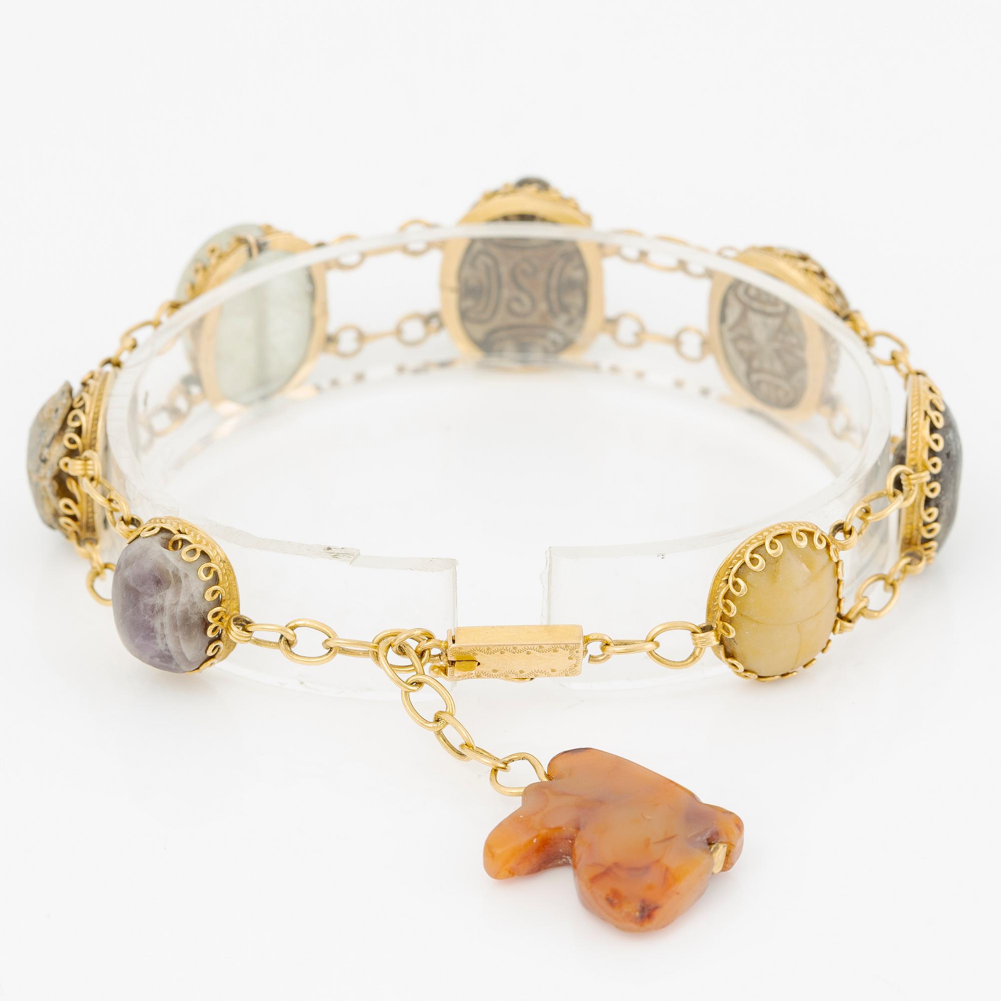 Bracelet in 14K gold with various minerals and scarab-shaped charms.
