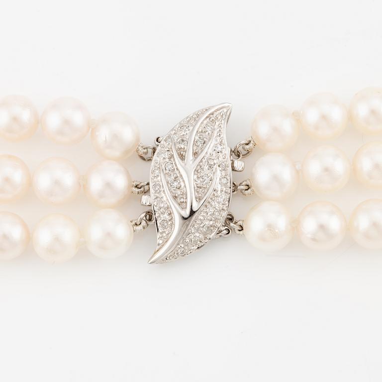 Necklace, pearls, three strands, clasp in 14K white gold with small diamonds.