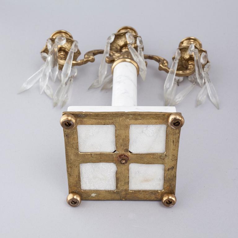 A French mantlepiece clock and a pair of candelabras, first half of the 20th century.