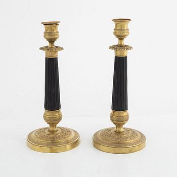 A pair of brass candle sticks, late empire, mid 19th century.