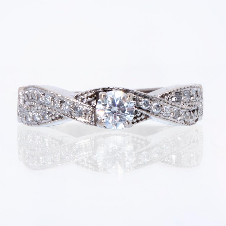 Ring 18K vitguld med 1 briljant ca 0,30 ct och briljanter ca 0,15 ct totalt.