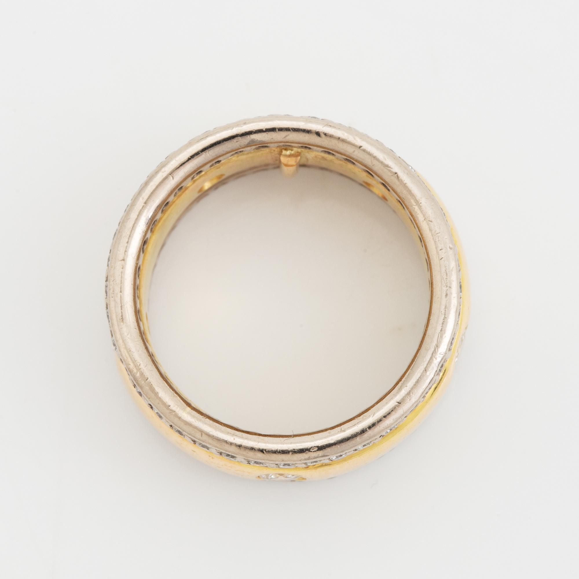 An 18K gold ring set with round brilliant-cut diamonds.