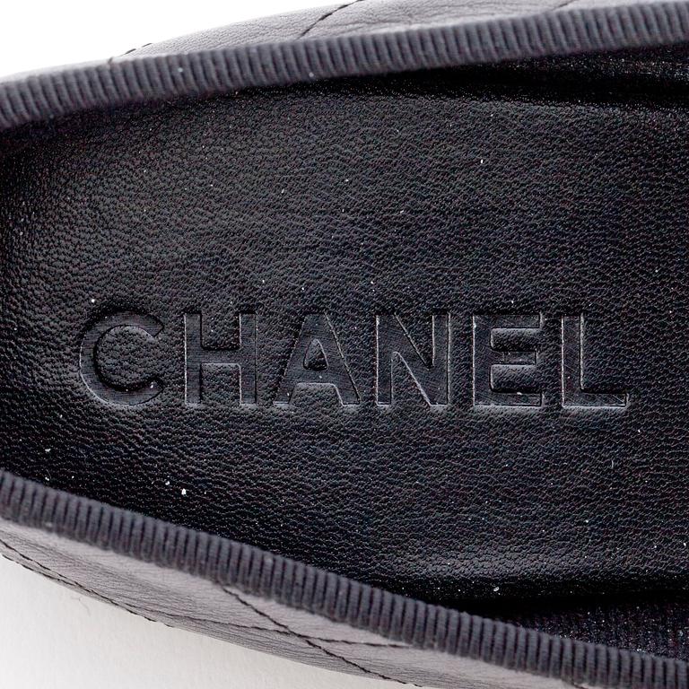 CHANEL, a pair of black leather ballet flats.