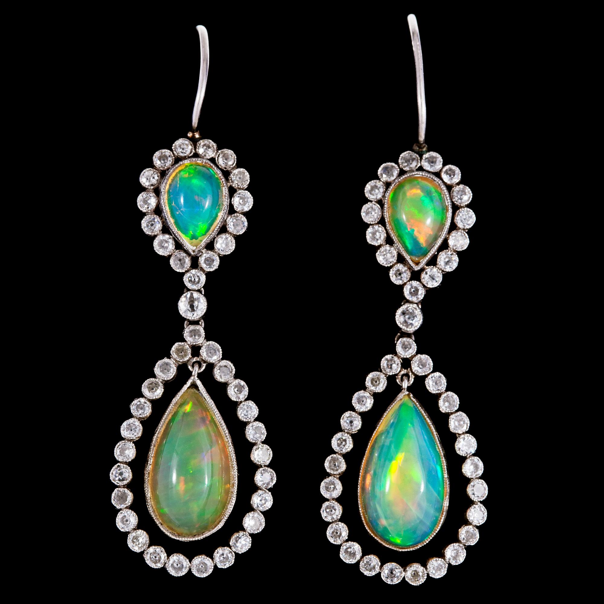ÖRHÄNGEN, cabochonslipad opal med krans av små diamanter, tot. ca 0.90 ct.