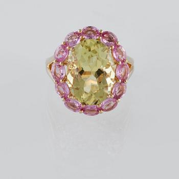 RING, 18K guld med ovalslipad topas ca 6.21 ct samt rosa safirer ca 2.25 ct. Vikt 6,2 gram.